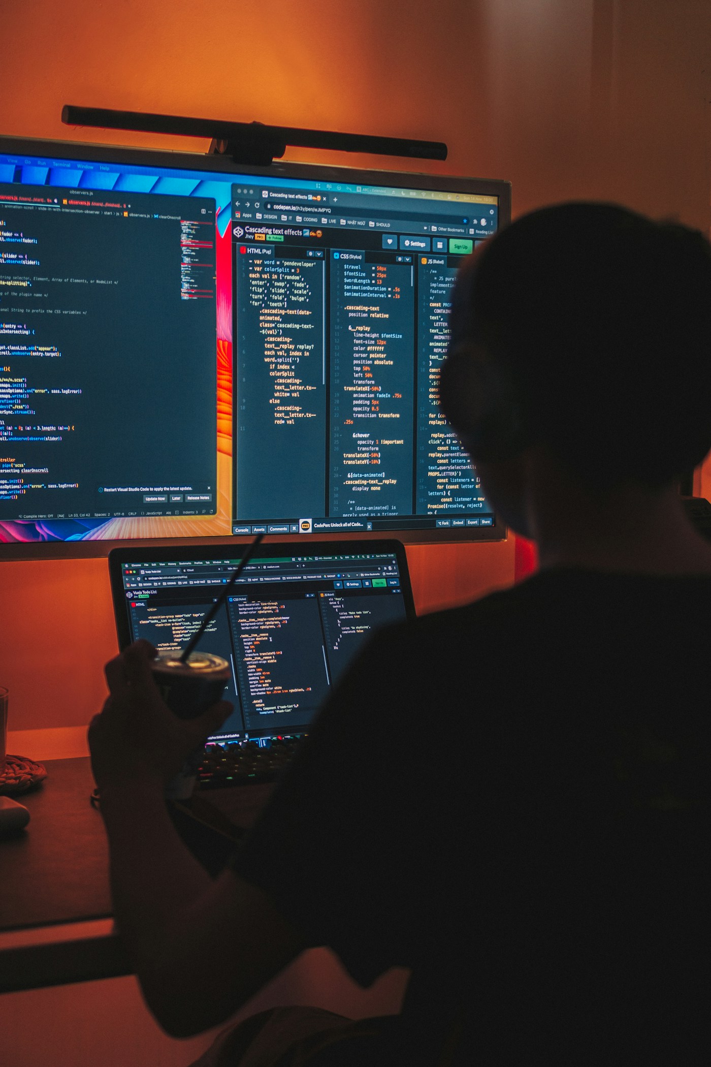 Developer working on code across two monitors